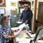 City and Borough of Juneau Assembly candidate Chuck Collins turns in his paperwork to City Clerk Laurie Sica on Monday. Collins said the people of Juneau &ldquo;need to take control of our town again.&rdquo; (Alex McCarthy | Juneau Empire)