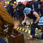 Coast Guard crewmembers use sledge hammers to seal a rivet pin to a shackle during the heat-and-beat competition aboard the Coast Guard Cutter Hickory at the Buoy Tender Roundup Olympics in Juneau on Wednesday, Aug. 16. Crews aboard Coast Guard buoy tenders in Alaska service 1,350 navigational aids along 33,000 miles of coastline while actively participating in search and rescue, environmental protection and law enforcement missions. (Petty Officer 1st Class Jon-Paul Rios | U.S. Coast Guard)