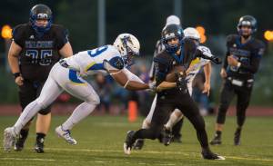 Thunder Mountain&rsquo;s Hansel Hinckle is chased by Kodiak&rsquo;s Jherome LaDera at TMHS on Friday, Aug. 18, 2017. TMHS won 14-7. (Michael Penn | Juneau Empire)