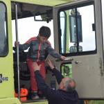 Firefighter Mark Fuette helps a child out of the Aircraft Response Firefighting vehicle after taking a ride at a barbecue and celebration for the airport fire station&rsquo;s remodel on Saturday. (Kevin Gullufsen | Juneau Empire)