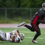 Juneau-Douglas&rsquo; quarterback Bubba Stults breaks a tackle attempt by Ketchikan&rsquo;s Tarrent Sasser at Adair-Kennedy Memorial Field on Saturday, Aug. 19, 2017. JDHS won 32-8. (Michael Penn | Juneau Empire)