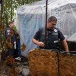 Juneau Police Department Sgt. Krag Campbell, left, and Officer Ken Colon serve eviction notices on homeless encampments as Alaska Mental Health Trust Authority employees look on on Tuesday, Aug. 22, 2017. (Michael Penn | Juneau Empire)