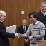 Jason Africano, originally from the Philippines, is congratulated by Immigration Services Officer Eric Dixon, left, during a Naturalization Ceremony overseen by Magistrate Judge Scott Oravec of Fairbanks, right, at the Robert Boochever Federal Courthouse in Juneau on Friday, Aug. 25, 2017. (Michael Penn | Juneau Empire)