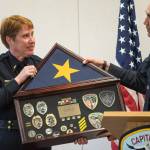Lt. Kris Sell receives a framed case of her badges and awards from Police Chief Ed Mercer at her retirement party at the Juneau Police Department on Thursday, Aug. 31, 2017. Sell started as a patrol officer in 1997.