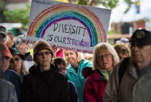 Heather Hardcastle holds a diversity sign while attending a Unity Rally against recent racial violence in Charlottesville at Marine Park on Sunday, August 27, 2017. (Michael Penn | Juneau Empire)