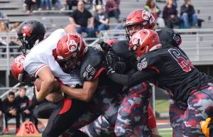 Juneau running back Liam Van Sickle gets tackled by several Kenai defenders, including James Siamani (25) and John Grossl (65) Saturday afternoon at Ed Hollier Field in Kenai. (Joey Klecka | Peninsula Clarion)