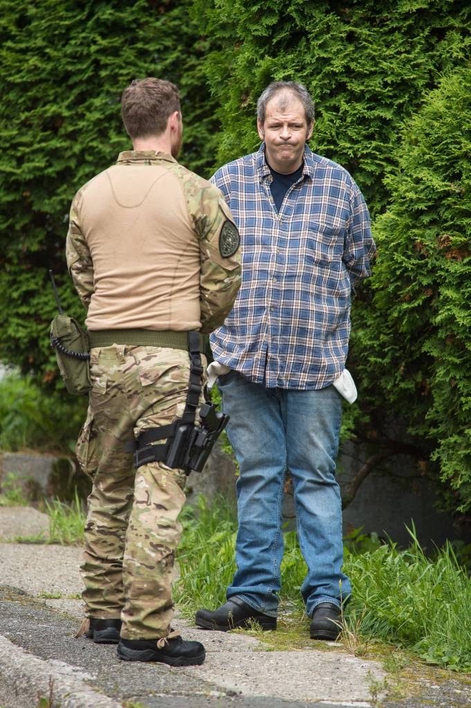 James Barrett is handcuffed and questioned by police while his house at 401 Harris Street is searched on Tuesday, Aug. 29, 2017. (Michael Penn | Juneau Empire)