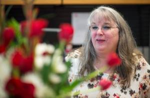 Linda Price works at her desk decorated with flowers by Branch Manager Tyler Davis at the Valley branch of Wells Fargo Bank on Tuesday, Aug. 29, 2017. Price is retiring after 19 years with Wells Fargo. (Michael Penn | Juneau Empire)