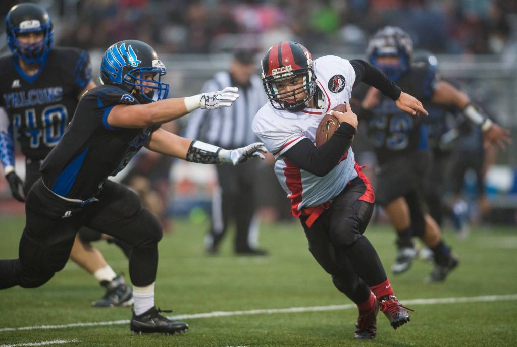 Thunder Mountain&rsquo;s Roy Tupou, left, chases Juneau-Douglas&rsquo; Liam Van Sickle at TMHS on Friday, Sept. 1, 2017. TMHS won 10-7 in overtime. (Michael Penn | Juneau Empire)