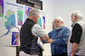In this April 2011 photo, Juneau Mayor Bruce Botelho, left, and former Juneau Rep. Bill Hudson, right, speak with John Torgerson, chairman of the Alaska Redistricting Board during a break in hearing public testimony at the Capitol. (Michael Penn | Juneau Empire File)