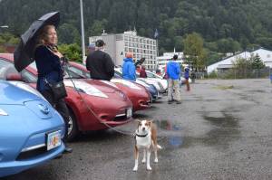 Electric vehicle owner Nanci Spear and her dog Blaze stand next to Spear&rsquo;s Nisan Leaf. The pair attended the Electric Vehicle (EV) Round Up at the Juneau Subport downtown. (Kevin Gullufsen | Juneau Empire)