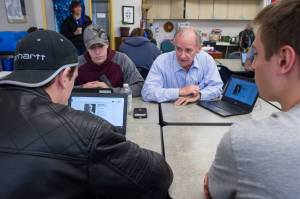 School Board candidate Jeff Short works with seniors Derick Nebert, left, Dakota Biddinger, center, and Hayden Bryson in Mara Sheakley-Early&rsquo;s first-period government class at Thunder Mountain High School on Wednesday, Sept. 20, 2017. (Michael Penn | Juneau Empire)