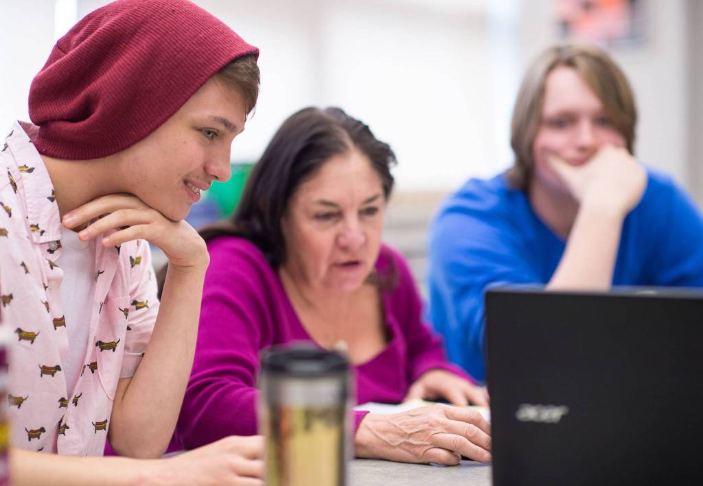 Assembly candidate Loretto Jones, center, works with seniors Cameron Okins, left, and Joshua Dore in Mara Sheakley-Early&rsquo;s first-period government class at Thunder Mountain High School on Wednesday, Sept. 20, 2017. (Michael Penn | Juneau Empire)