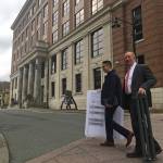 Attorneys Jon Choate, left, and Mark Choate, right, cross 4th Street on Thursday, Sept. 21, 2017. The two men were carrying exhibits to be used in their lawsuit against the state of Alaska on behalf of the Alaska Democratic Party. At background is the Alaska State Capitol. (James Brooks | Juneau Empire)
