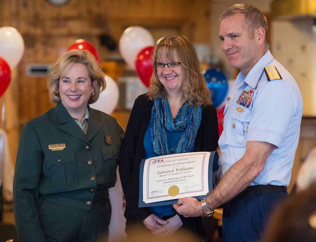 Standing in for her husband, Pam Williams, center, is presented with the Community Service Award by Regional Forester Beth Pendleton and Rear Admiral Michael McAllister, Commander of the U.S. Coast Guard&rsquo;s 17th District, at the Juneau Federal Executive Association&rsquo;s 2016-2017 Federal Employee of the Year Award Banquet and Ceremony at the Twisted Fish on Tuesday, Oct. 3, 2017. (Michael Penn | Juneau Empire)