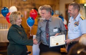 David Hydock, center, is presented with the Professional Achievement Award by Regional Forester Beth Pendleton and Rear Admiral Michael McAllister, Commander of the U.S. Coast Guard&rsquo;s 17th District, at the Juneau Federal Executive Association&rsquo;s 2016-2017 Federal Employee of the Year Award Banquet and Ceremony at the Twisted Fish on Tuesday, Oct. 3, 2017. (Michael Penn | Juneau Empire)