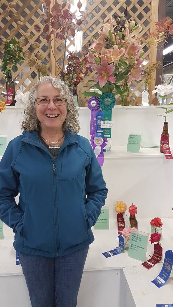 Nell McConahey at the Alaska State Fair with her award-winning lilies. McConahey won four awards at the Alaska State Fair this year: Best of Show, Judges Choice, first place for hybrid lilies and first place overall for lilies. (Courtesy photo)