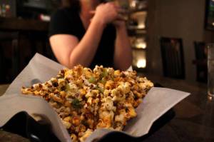 V&rsquo;s Cellar Door owner Venietia Santana sits near her newest menu item, the Shiz Boom Pop! Corn, at her restaurant on Oct. 5, 2017. V&rsquo;s Cellar Door is one of 15 restaurants involved with Downtown Restaurant Week. (Alex McCarthy | Juneau Empire)