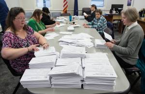 Members of the Absentee Questioned Ballot Review Board open ballots before counting at the City Hall on Friday, Oct. 6, 2017. (Michael Penn | Juneau Empire)