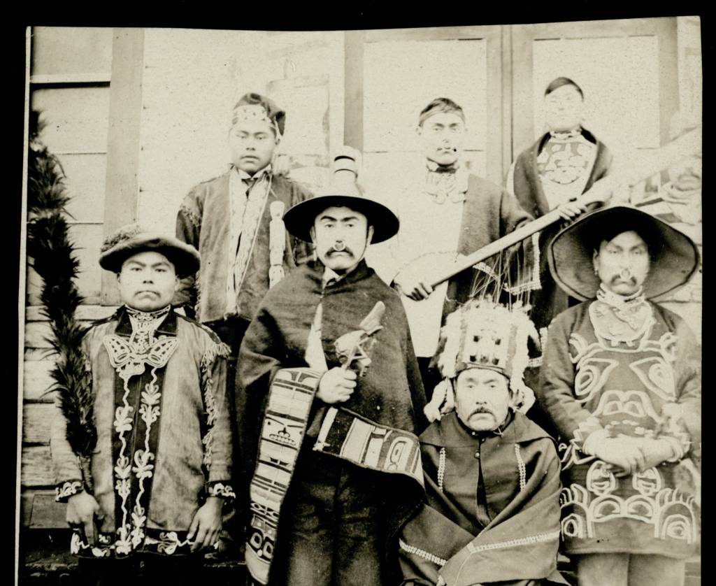 In this 1924 photo, Archie White, third from left, then the clan leader of the T&rsquo;akdeintaan and the leader of the Mount Fairweather House in Hoonah, is wearing a blanket with Chilkat trim. After an absence of almost 100 years, that same blanket was repatriated to the Hoonah Indian Association on Wednesday, October 11, 2017. Archie White&rsquo;s Tlingit names were Tuk&rsquo;axaaw and Yookis&rsquo;kook&