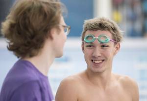 Chris Ray talks to coach Josiah Loseby at Thunder Mountain High School swim practice at Dimond Park Aquatics Center on Wednesday, Oct. 25, 2017. (Michael Penn | Juneau Empire)
