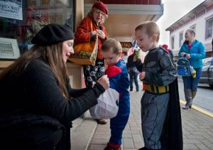 In this Oct. 31, 2016 photo, Lisa Ryals, owner of Lisa Davidson&rsquo;s Boutique, hands out candy to trick-or-treaters Kyesin Davidson, 4, right, and his brother, CJ, for Halloween. (Michael Penn | Juneau Empire File)