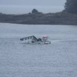 A fellow boater comes to the aid of a boat in the process of sinking in Indian Cove in Juneau on Oct. 30, 2017. The boat has about 150 gallons of diesel fuel on it, according to the Coast Guard. (Alex McCarthy | Juneau Empire)