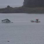 A fellow boater comes to the aid of a boat in the process of sinking in Indian Cove in Juneau on Oct. 30, 2017. The boat has about 150 gallons of diesel fuel on it, according to the Coast Guard. (Alex McCarthy | Juneau Empire)
