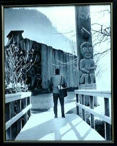 Chris Neilson holds the author&rsquo;s canvas shopping bag for her- on the stock up trip when she broke her ankle - and gazes at the totem poles on Shakes Island in Wrangell. Courtesy of Tara Neilson.