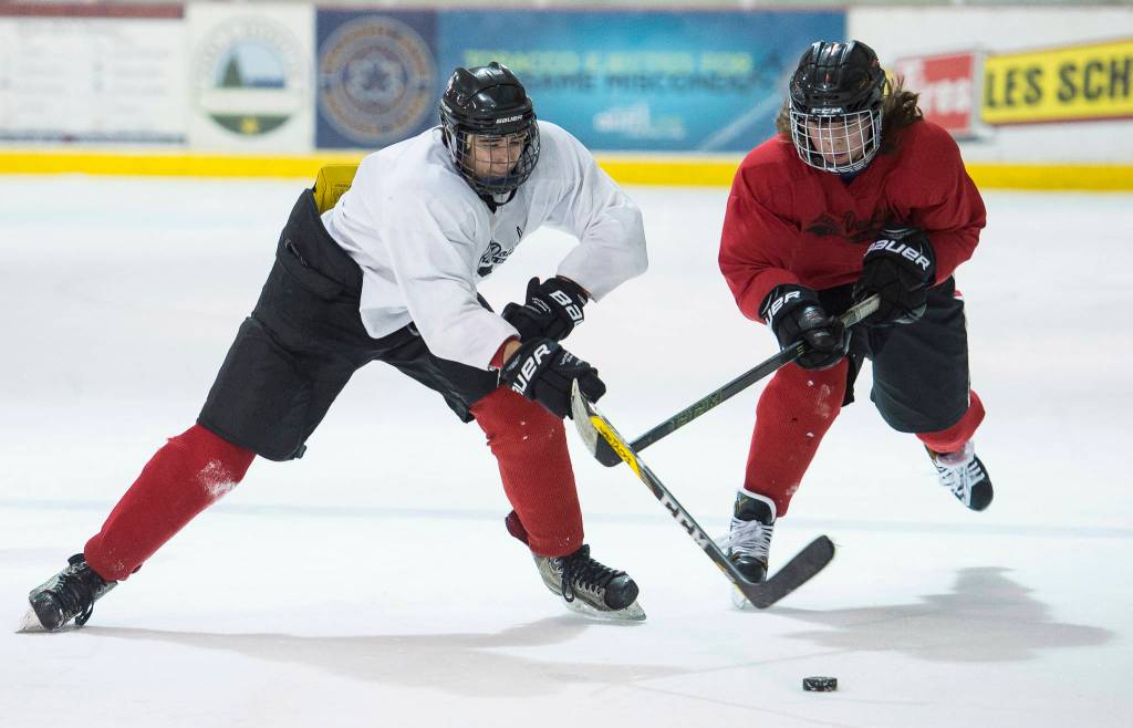 Cully Corrigan, left, passes away from Bill Bosse, right, with Joseph Monsef in the background during Juneau-Douglas High School hockey practice at the Treadwell Arena on Thursday, Nov. 16, 2017. (Michael Penn | Juneau Empire)