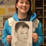 Thunder Mountain High School senior Ashyton Ashcroft poses with a portrait she made as part of the Memory Project. The project sends portraits to children in distress all over the world, giving them a keepsake. (Photo courtesy of Angela Imboden)