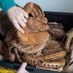 KC Mack shows used mitts he collects for making wallets from on Friday, Nov. 17, 2017. (Michael Penn | Juneau Empire)