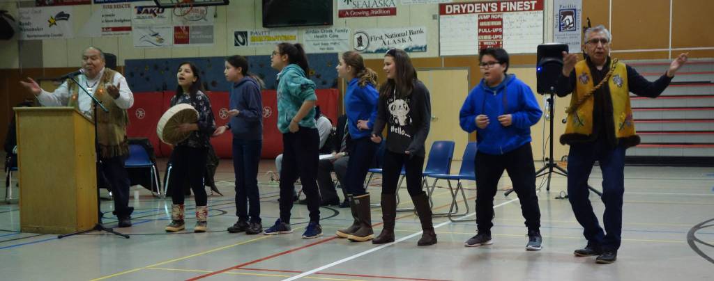 Floyd Dryden Middle School students sing Tlingit song about respecting elders and community members, accompanied by David Katzeek on the left and Paul Marks on the right, at the &ldquo;Transfer of Core Cultural Values Panels Ceremony&rdquo; at Floyd Dryden Middle School on Wednesday, Nov. 22. (Clara Miller | Capital City Weekly)