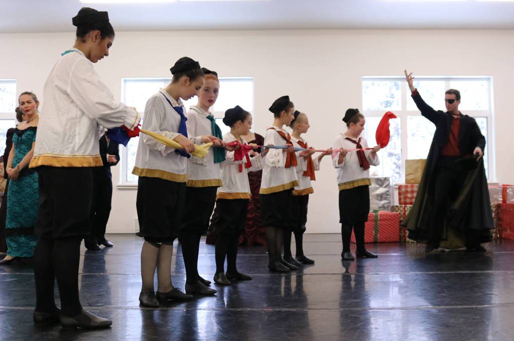 Artistic Director of the Juneau Dance Theater Zachary Hench, right, plays Clara&rsquo;s mysterious godfather, Herr Drosselmeyer, who entertains everyone during the party scene with magic tricks. Here, children hold a magic scarf. (Erin Laughlin | For the Capital City Weekly)
