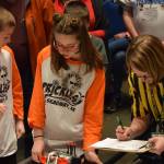 Members of team Prickles, of Skagway, go over scoring with a Juneau Robot Jamboree judge at the robot game on Saturday at Centennial Hall Convention Center. (Kevin Gullufsen | Juneau Empire)