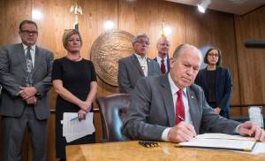 Gov. Bill Walker signs an Executive Order in his Capitol conference room on Tuesday, Oct. 31, 2017, outlining his administration&rsquo;s policy on climate change and creating the Climate Action for Alaska Leadership Team. Standing behind Gov. Walker are Department of Commerce, Community & Economic Development Deputy Commissioner Fred Parady, left, Attorney General Jahna Lindemuth, Lt. Gov. Byron Mallott, Department of Environmental Conservation Commissioner Larry Hartig and Senior Advisor on Climate Change Dr. Nikoosh Carlo. (Michael Penn | Juneau Empire File)