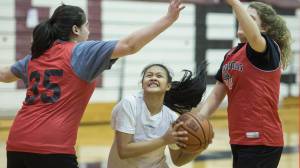 Alyxn Bohulano drives to the basket between teammates Chloe McAdams, left, and Skylar Hickok at Juneau-Douglas High School girls basketball practice on Thursday, Dec. 7, 2017.