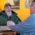 Russell Peterson, left, meets and thanks Guy Holt on Tuesday, Dec. 19, 2017, for returning a carved plaque Holt found 11 years ago at Sandy Beach. Peterson carved the plaque and left it at the gravesite of his dog, Taka. (Michael Penn | Juneau Empire)
