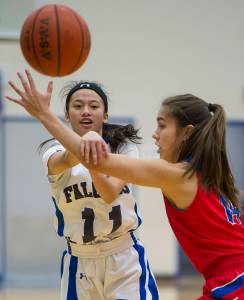 Thunder Mountain&rsquo;s Neal Garcia, left, passes against Sitka&rsquo;s Marlis Boord on Thursday, Dec. 21, 2017. Sitka won the game. (Michael Penn | Juneau Empire)