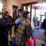 In this March 10 photo, Juneau police officers escorts a tenant out of the Bergmann Hotel at the city closed the building for health and safety reasons. (Michael Penn | Juneau Empire File)