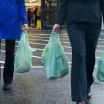 Shoppers carry their groceries out of Super Bear with plastic bags in October 2016. (Michael Penn | Juneau Empire File)