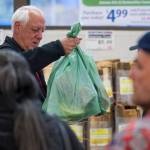 Mayor Ken Koelsch bags groceries for customers during an event at Super Bear in October 2016. (Michael Penn | Juneau Empire File)