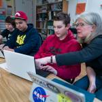 Math Specialist Brenda Taylor helps eighth-graders Fisher Lee, right, and Jorge Cordero, center, and sixth-grader Joshua Kessler with their coding project at the Juneau Community Charter School on Wednesday, Jan. 10, 2018. The school is celebrating its&nbsp;20th Anniversary with a dinner and presentation in the Juneau-Douglas High School commons on Saturday from 5:30 to 9 p.m. (Michael Penn | Juneau Empire)