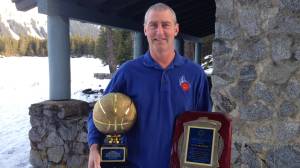 Steve Brandner, 57, poses with the Dr. Walter A. Soboleff Award, right, and a basketball trophy for his decades of support to the Juneau Lions Club Gold Medal Basketball Tournament last year at Skater&rsquo;s Cabin. Brandner retired from the Juneau School District last month and scaling back his involvement in the Gold Medal Tournament. (Courtesy photo | Monica Brandner)