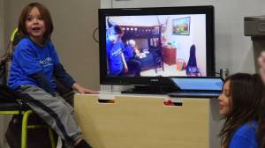 Greysen Fawcett, left, reacts during a video reveal of his new room on Saturday during a Make-a-Wish Foundation celebration at the Juneau Gymnastics Academy. (Kevin Gullufsen | Juneau Empire)