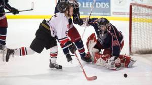 Juneau-Douglas&rsquo; Cully Corrigan scores on North Pole&rsquo;s goalie Moses Halbert as his helmet is knocked away by North Pole&rsquo;s Jeff Doty at Treadwell Arena on Friday, Jan. 19, 2018. (Michael Penn | Juneau Empire)