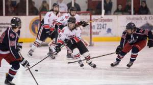 Juneau-Douglas&rsquo; Billy Bosse, moves the puck up against North Pole&rsquo;s Jesse Keith, right, at Treadwell Arena on Friday, Jan. 19, 2018. (Michael Penn | Juneau Empire)