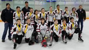 The Juneau Capitals pose with their championship medals after defeating the Vancouver Thunderbirds at the Sno-King Amateur Hockey Association&rsquo;s MLK 12-and-under tournament in Seattle. Coaches in back from left: David Kovach, Mike Bovitz, Jason Kohlhase. Players back row from left: Ian Moller, Luke Bovitz, John McElmurry, Busby West, Jackson White, Antone Araujo, Karter Kohlhase, Jaeger Dostal. Front row from left: Camden Kovach, Stein Dostal, Mason Sooter, Keegan Clancy, Caden Johns, Sonny Monsef. (Courtesy photo | Steve Quinn)
