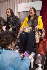 Heather Lee, right, and Michael George Patterson receive foot care during the Juneau Coalition on Housing & Homelessness&rsquo; 7th annual Project Homeless Connect in the Juneau Arts & Culture Center on Wednesday, Jan. 24, 2018. (Michael Penn | Juneau Empire)