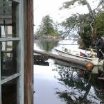Gary Neilson tows the new log to put into place behind his floathouse. Photo by Tara Neilson